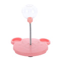 A close-up of a pink interactive cat toy with a single spring-mounted clear ball at the center, designed to hold treats. The toy base has two side compartments for additional treat balls, providing multiple points of engagement for cats.