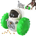 A white toy with green wheels designed to dispense treats for pets. A gray kitten and a brown and white dog are shown playing with the toy, which is dispensing small pieces of food. The toy features a transparent dome and multiple treat holes.